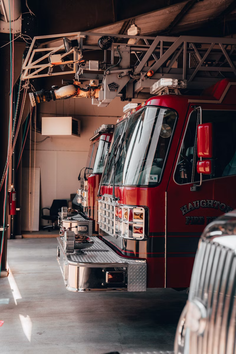 Fire trucks parked inside a fire station garage